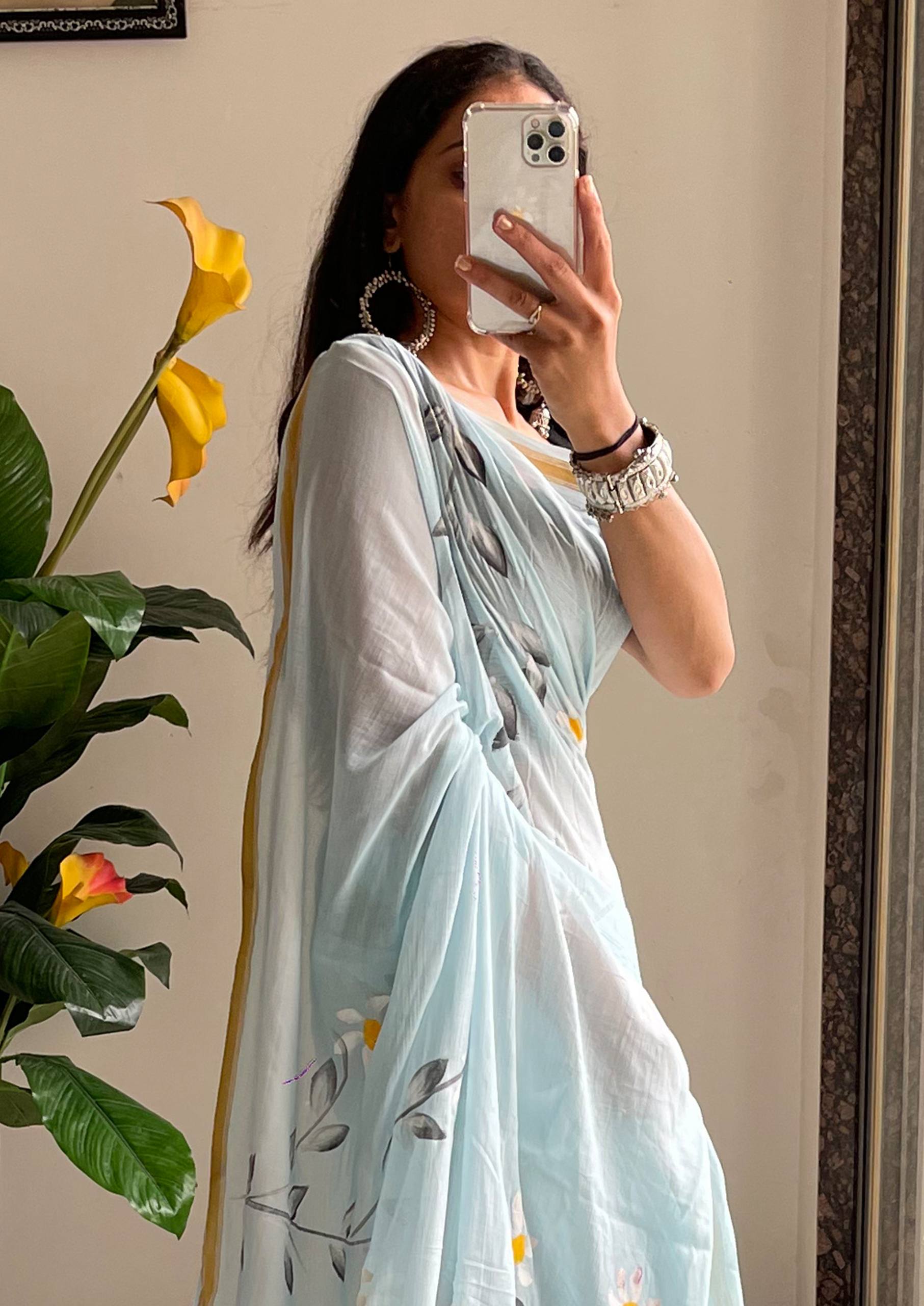 "A Serene Blue Saree With Soft Yellow and White Floral Accents"