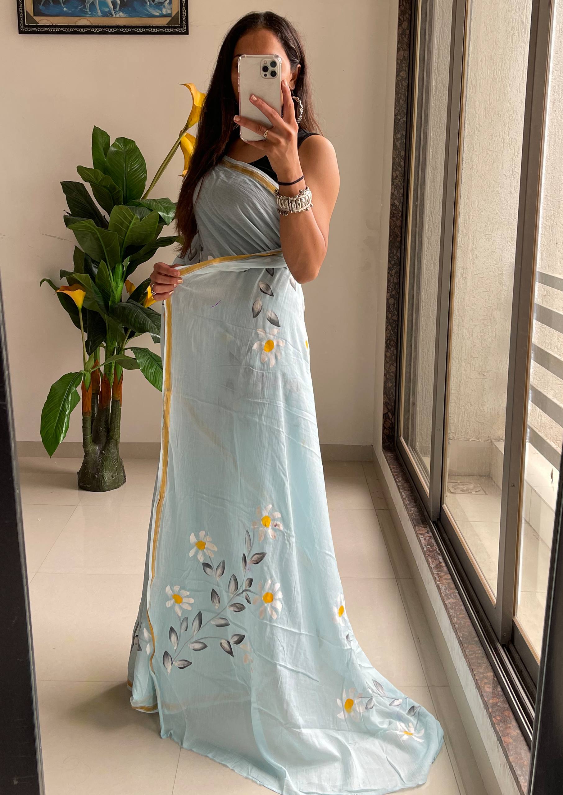 "A Serene Blue Saree With Soft Yellow and White Floral Accents"